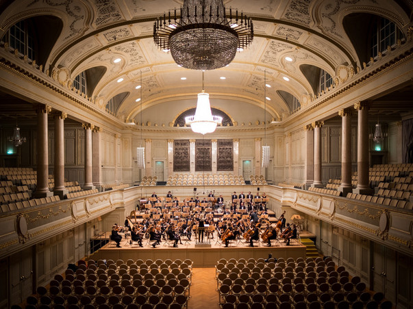 music group performing on stage with empty audience seats